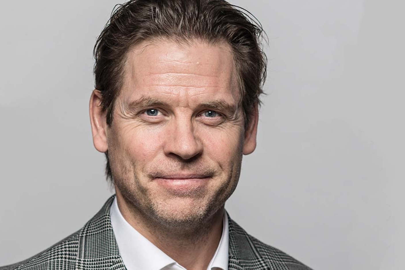 Person iförd rutig kavaj och vit skjorta.