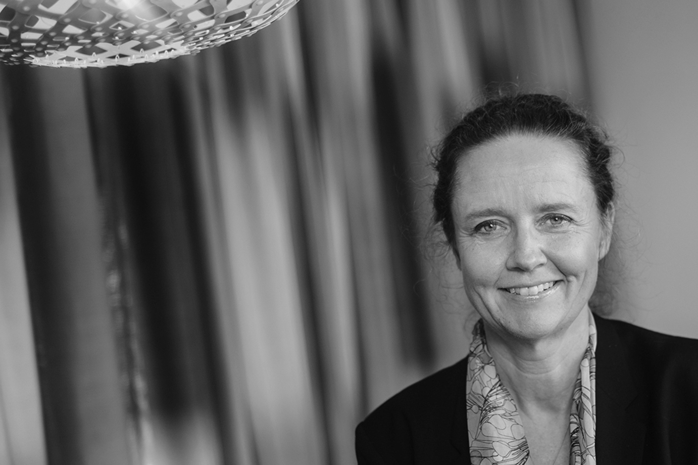 Person iförd mörk kavaj och sjal.