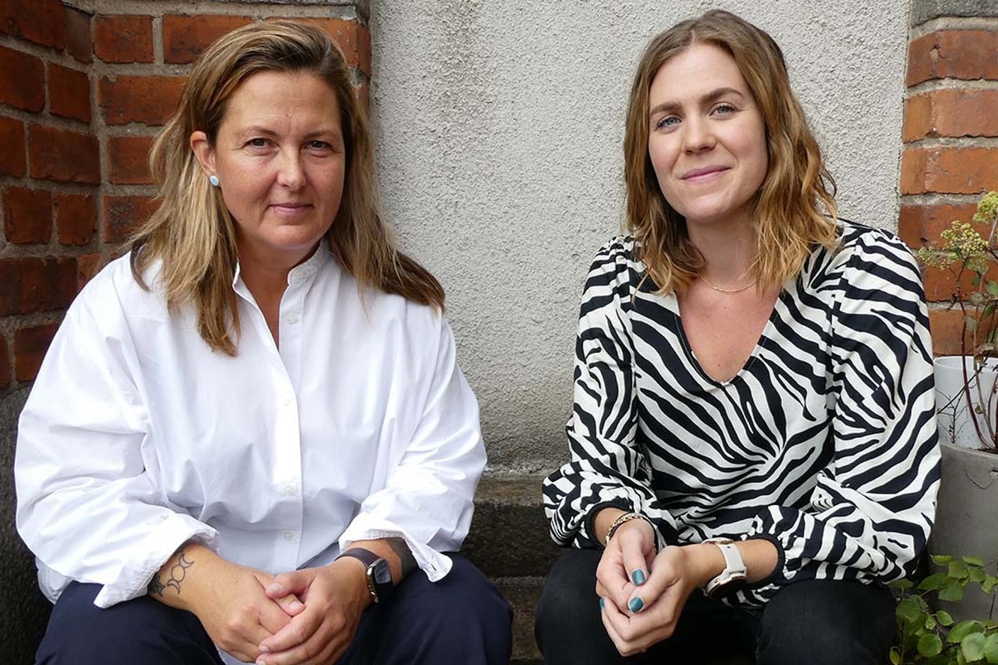 Två personer sitter på en trappa.