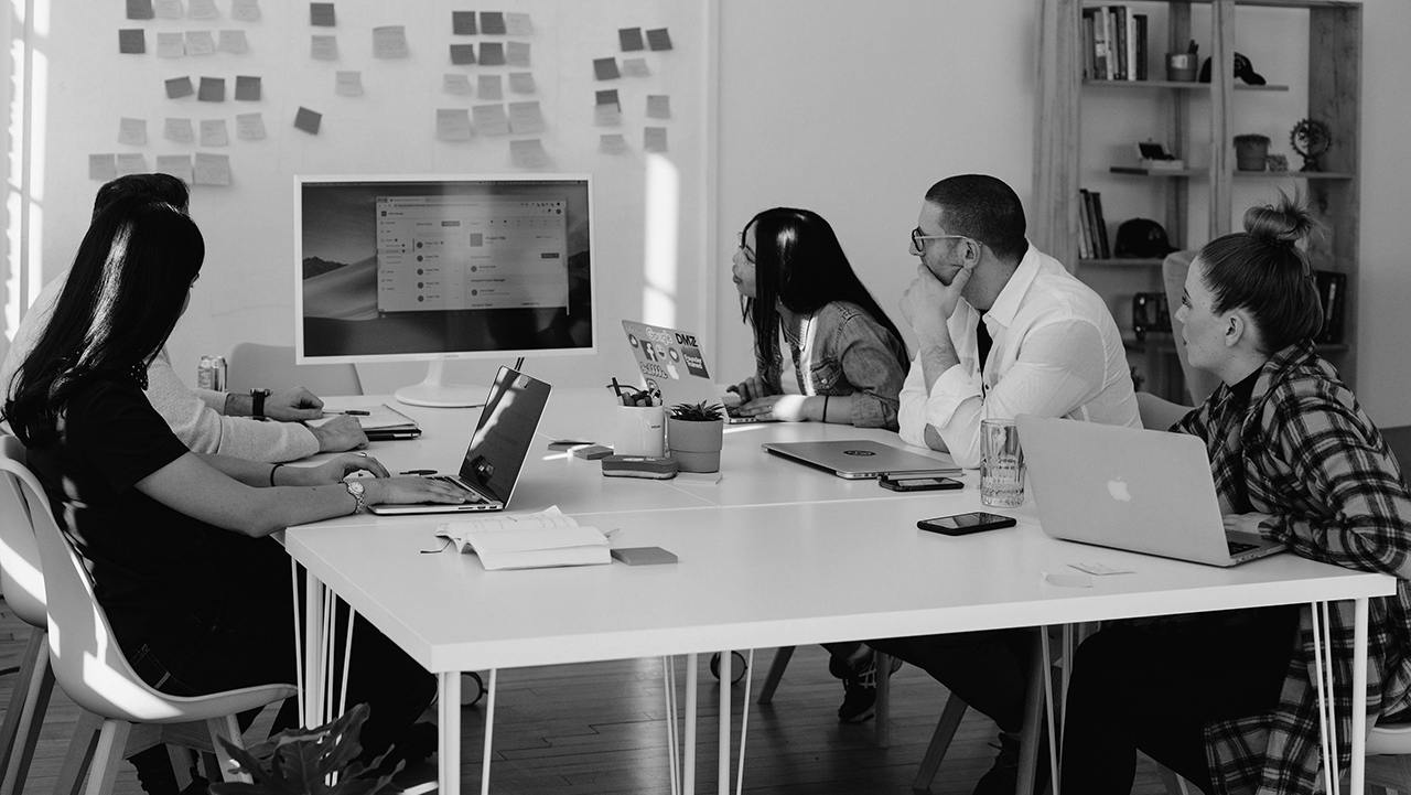 Personer runt ett bord i en mötessituation.