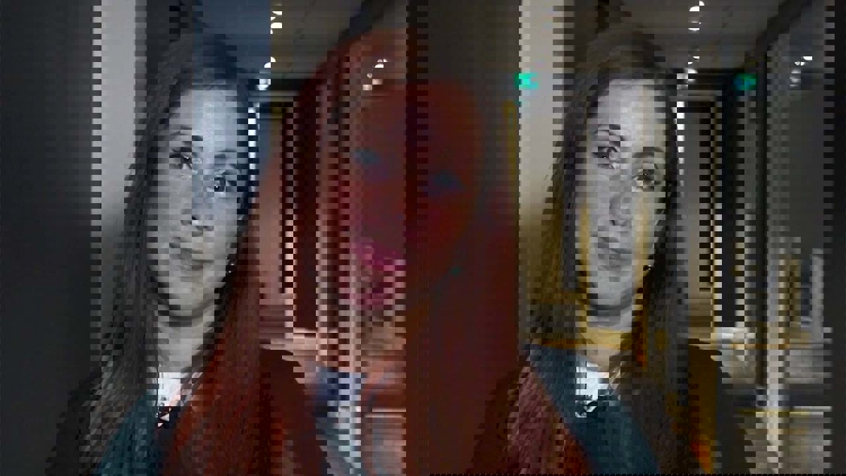 Person stående i kontorskorridor.