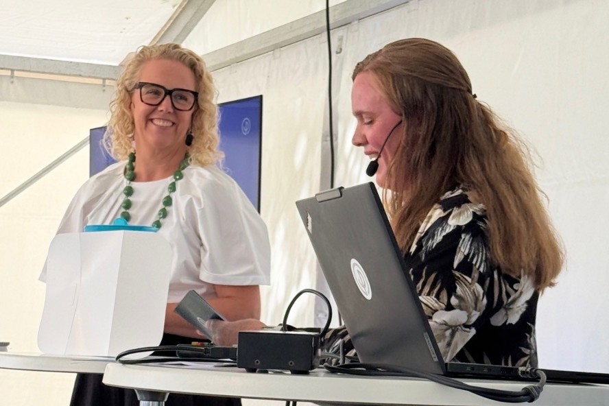 Två personer står i ett tält och samtalar under ett seminarium