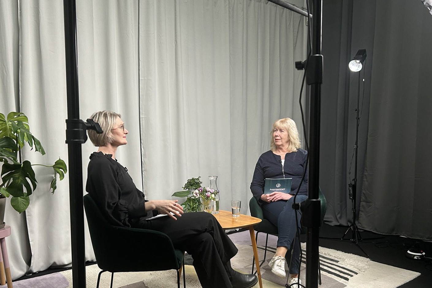 Två personer sitter i en studio och samtalar