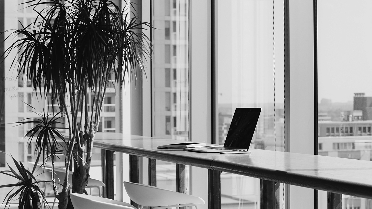 Dator stående i på ståbord framför panoramafönster.